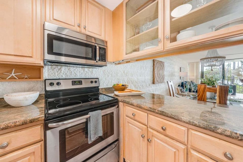 Well‑appointed kitchen featuring a full‑size oven and stove, light wood cabinets, and generous counter space for easy meal preparation.
