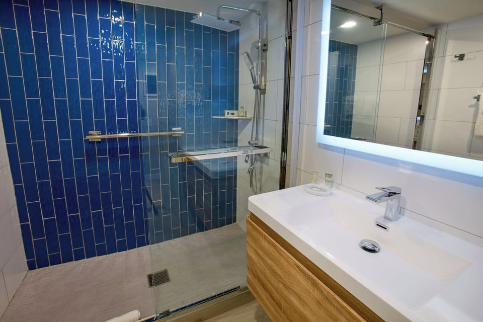 Rinse off in a glass walk-in shower, bright and spotless.