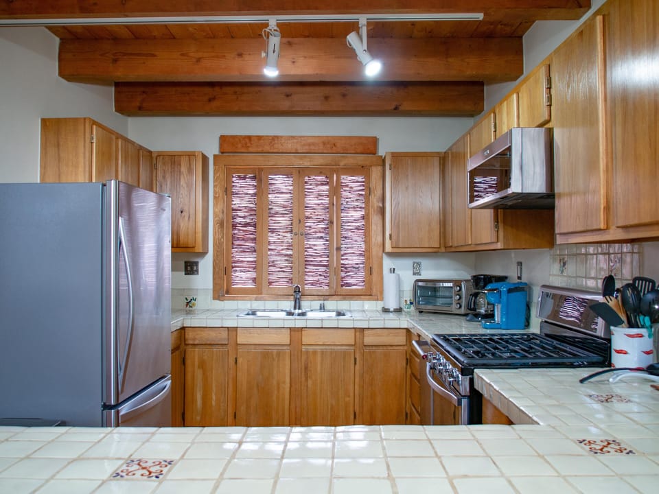 A kitchen with wooden cabinets and a stainless steel stove.
