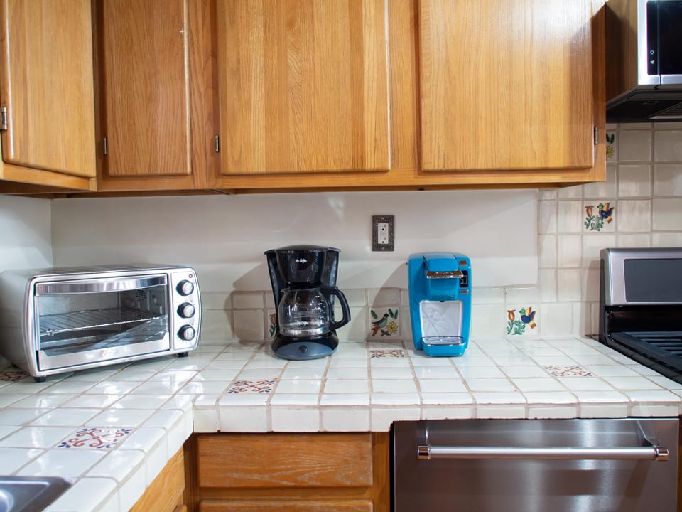 A kitchen with a microwave, toaster, and coffee maker.