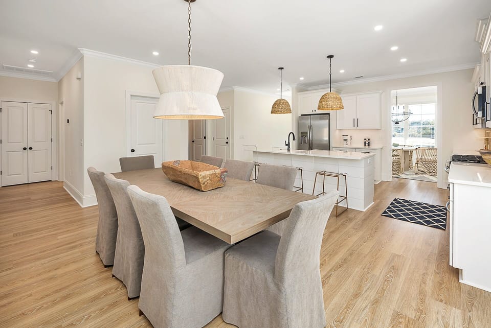 Dining table with seating for eight people open to the kitchen and living space.