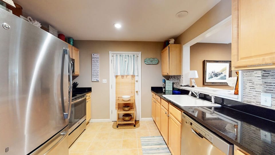 The fully equipped kitchen features stainless steel appliances, ample counter space, and a clean, functional layout