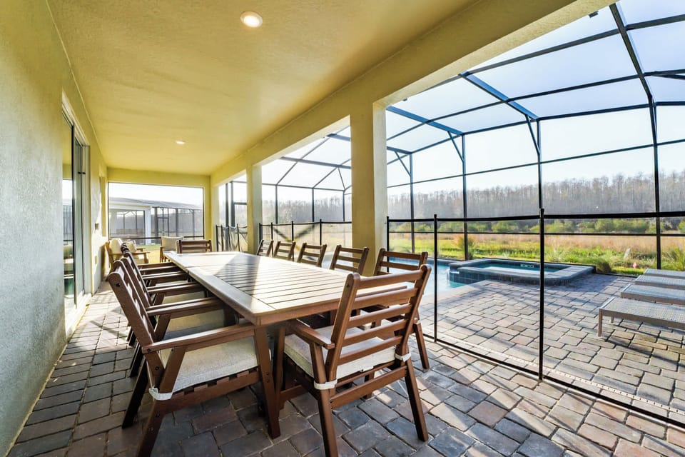 Enjoy alfresco dining on a spacious patio with stunning views of the pool and natural surroundings. Perfect for gatherings.