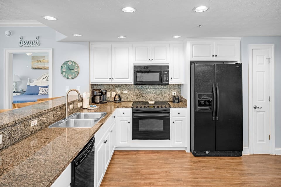Modern kitchen with granite countertops and black appliances