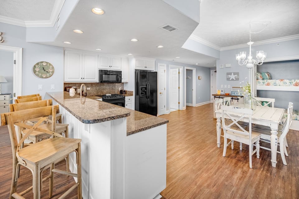open kitchen and dining area with granite countertops and wood flooring