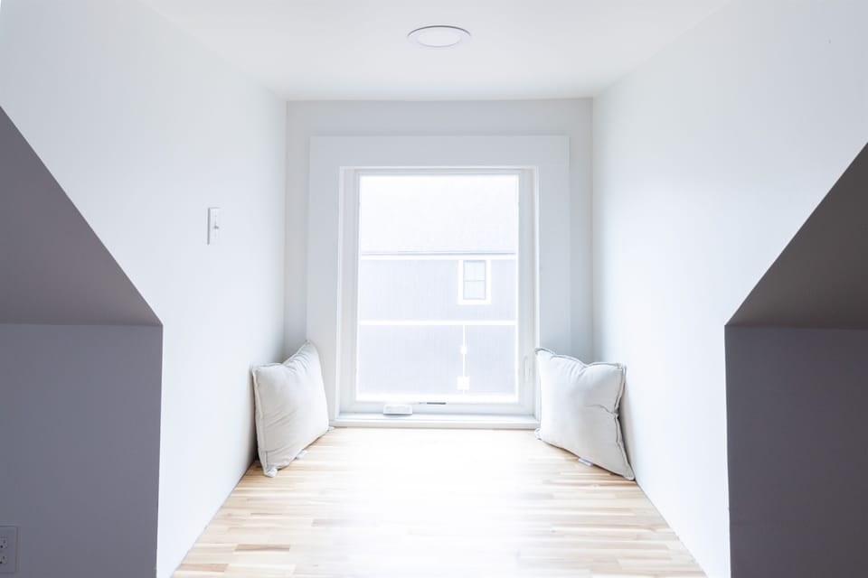 The large window in this third-floor bedroom lets in abundant light, creating a bright and inviting space.