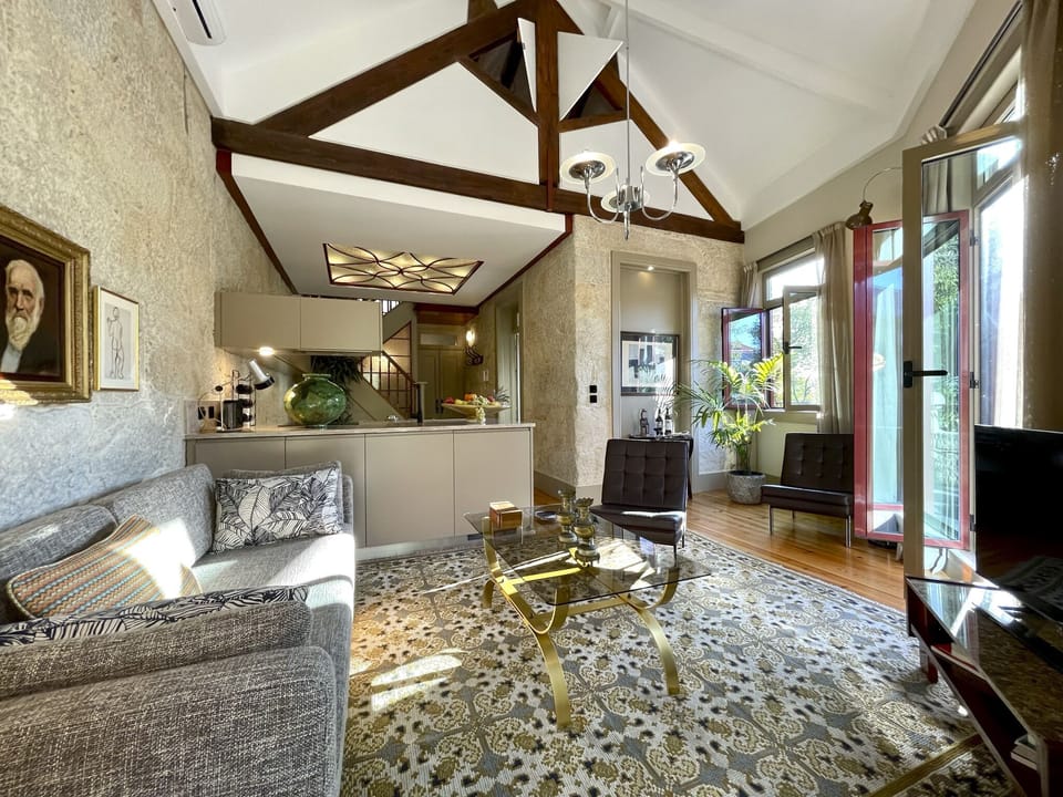 Double height living area with its old wooden structure and opening shutters 