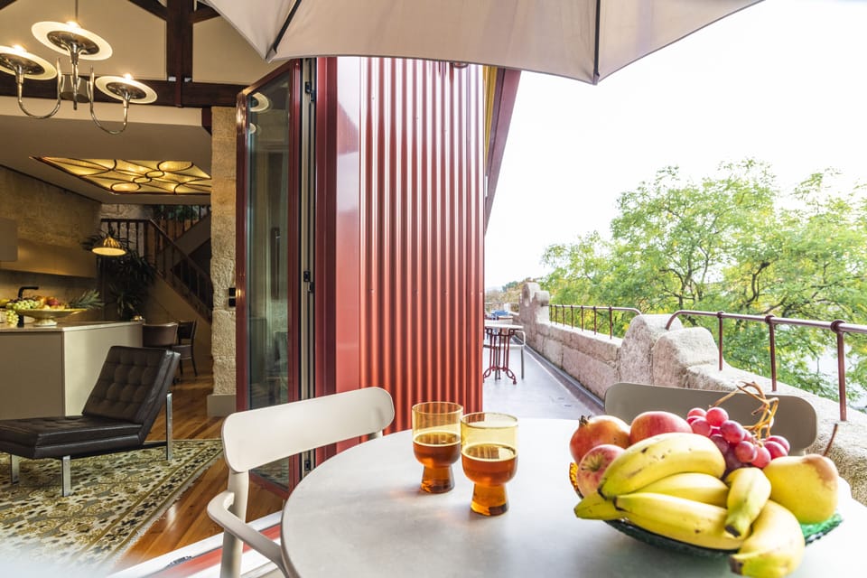 Sunny terrace facing the tall trees on the street with tables and chairs 