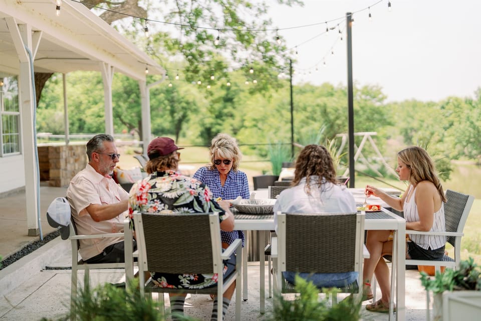Outdoor group dining surrounded by greenery at The Blanc lakefront home
