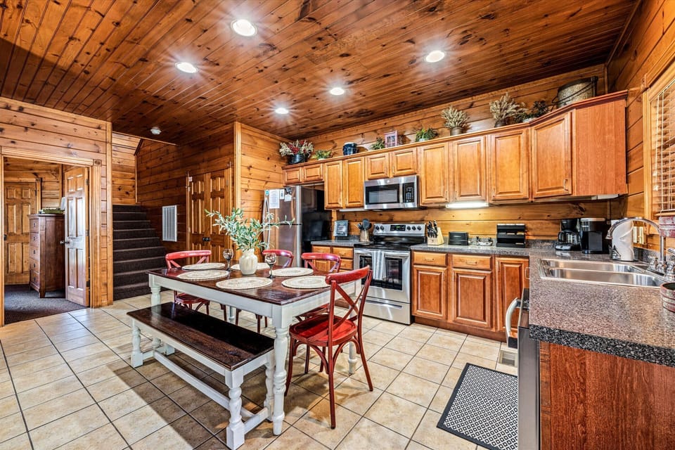 Fully equipped with stainless steel appliances, wooden cabinetry, and a large island for dining.