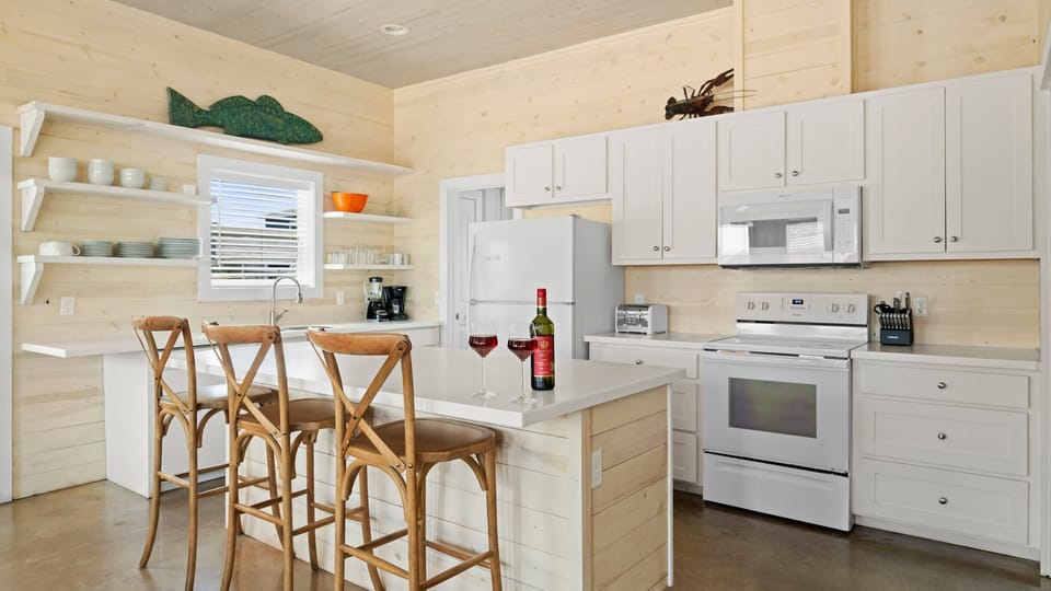 Kitchen — Bar Seating, Open Shelves & Coastal Fish Art