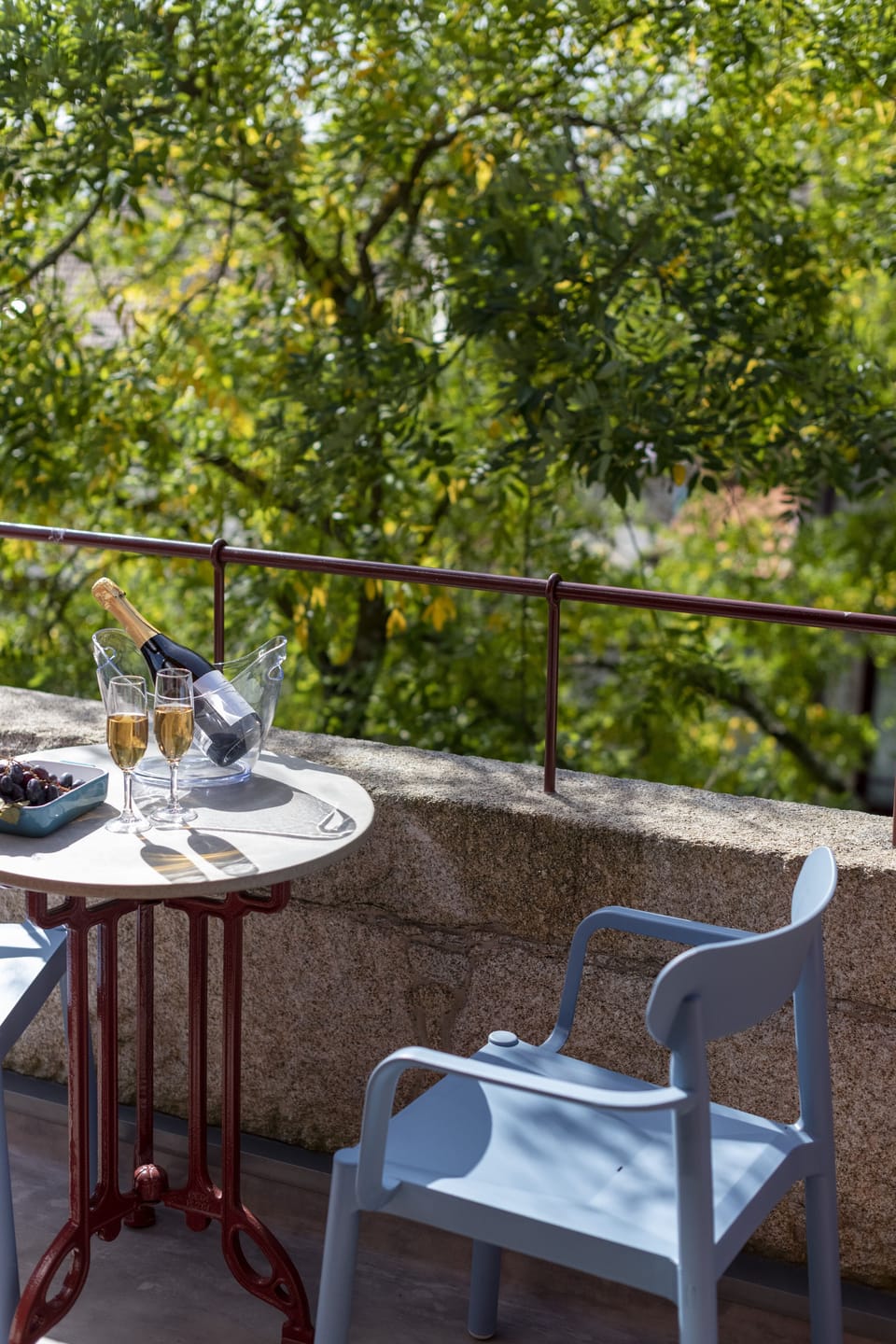 Sunny balcony on the top floor of the building facing the tall trees 