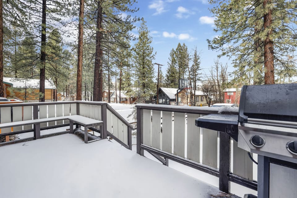 Welcoming cabin entry surrounded by towering pine trees, offering fresh mountain air and a peaceful forest setting—the perfect first impression for your Big Bear Lake getaway.