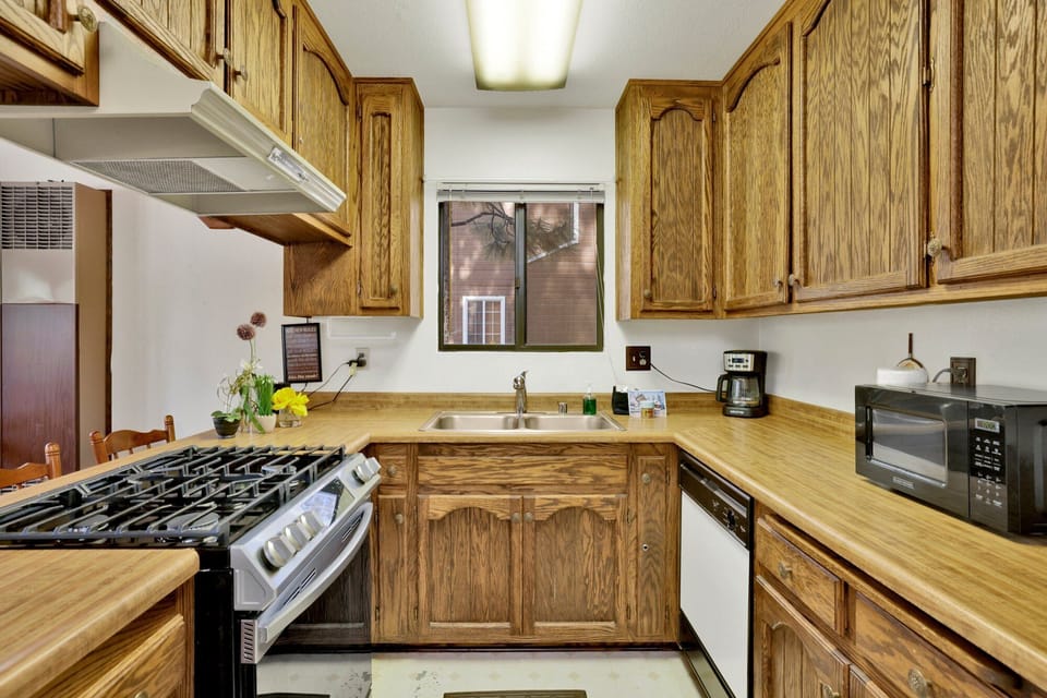 Fully equipped cabin kitchen with ample cabinetry, stove, fridge, microwave, and coffee maker—perfect for cooking meals, morning coffee, and feeling right at home on your stay.