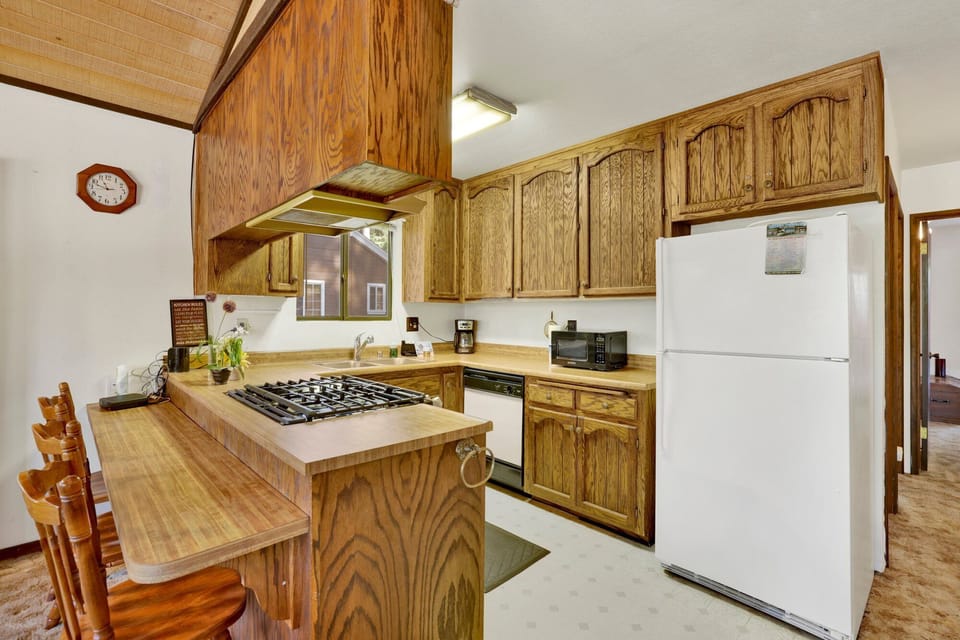 Fully equipped cabin kitchen with ample cabinetry, stove, fridge, microwave, and coffee maker—perfect for cooking meals, morning coffee, and feeling right at home on your stay.