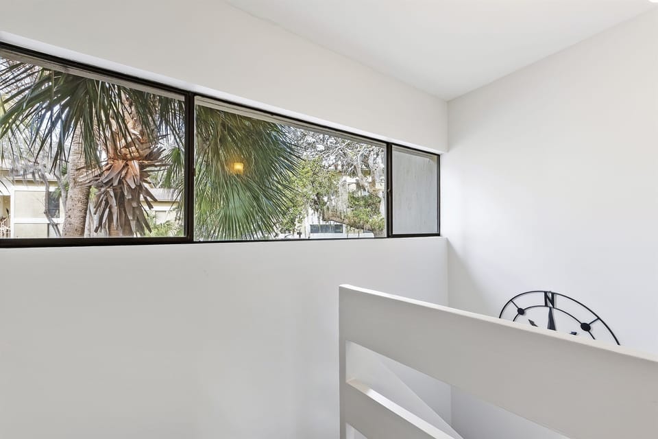 Ascend the staircase and enjoy glimpses of majestic Palmetto trees, adding a touch of natural beauty to your journey between floors.