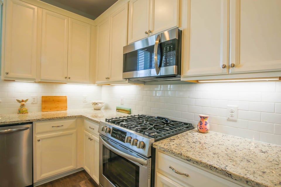 The kitchen features stainless steel appliances, including a gas stove, dishwasher and microwave.