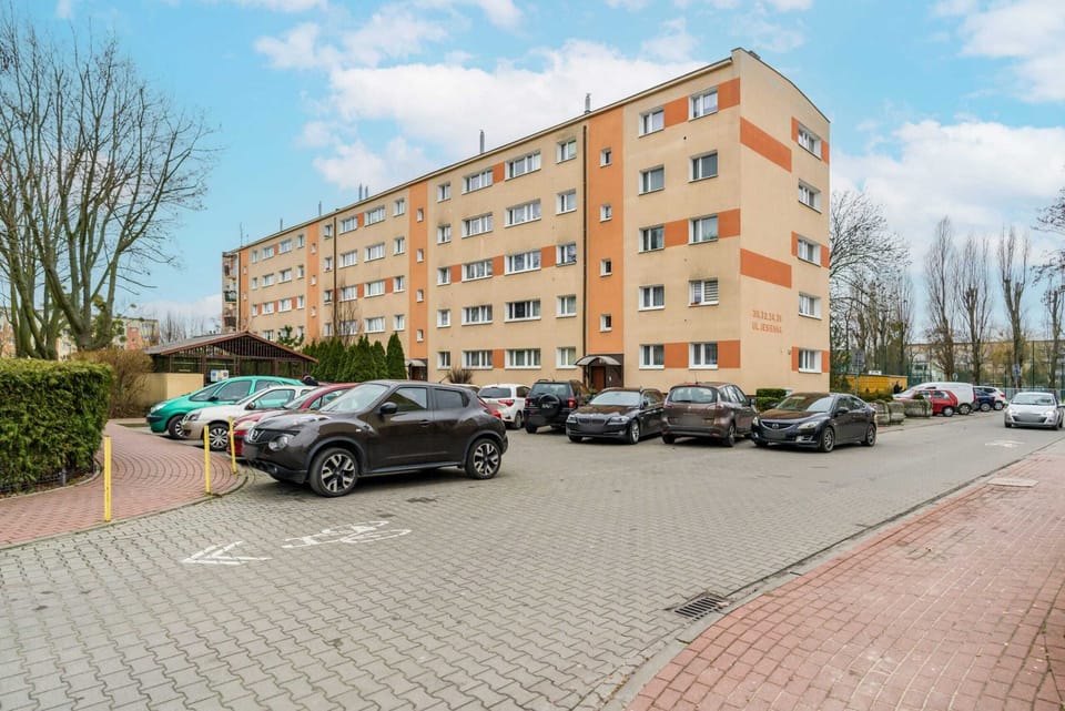 Another perspective of the building exterior, showing the neatly arranged parking and greenery.






