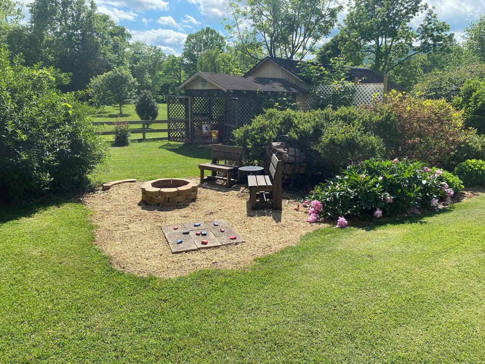 Fire pit with outdoor equipment shed behind.