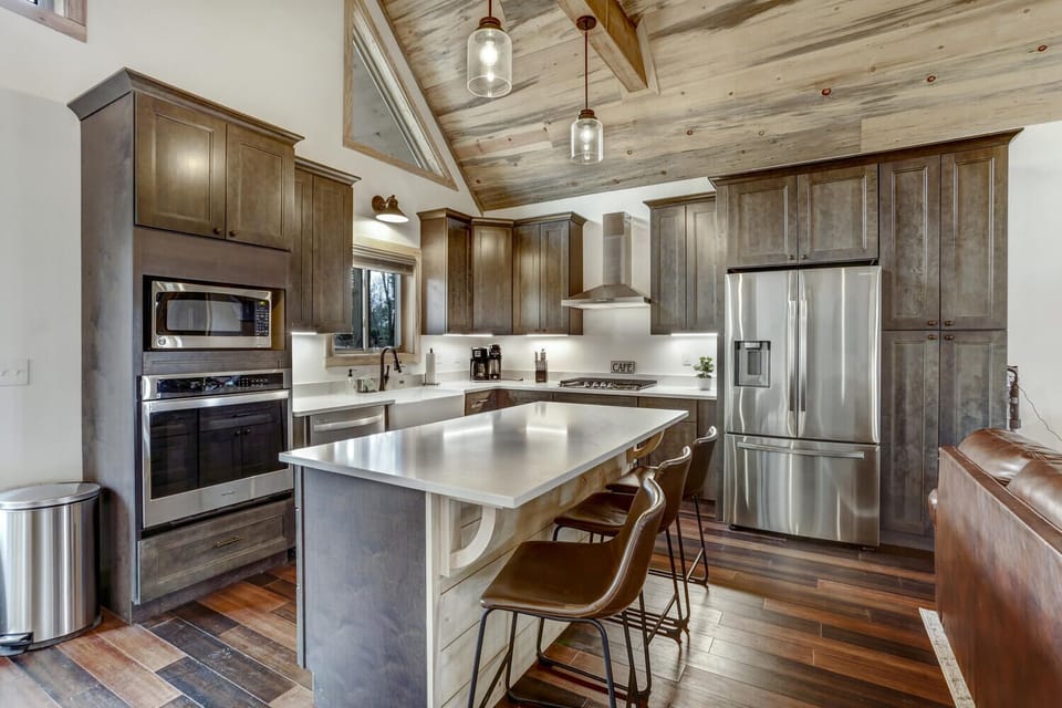 Well appointed kitchen with gas stove, large island and quartz countertops.