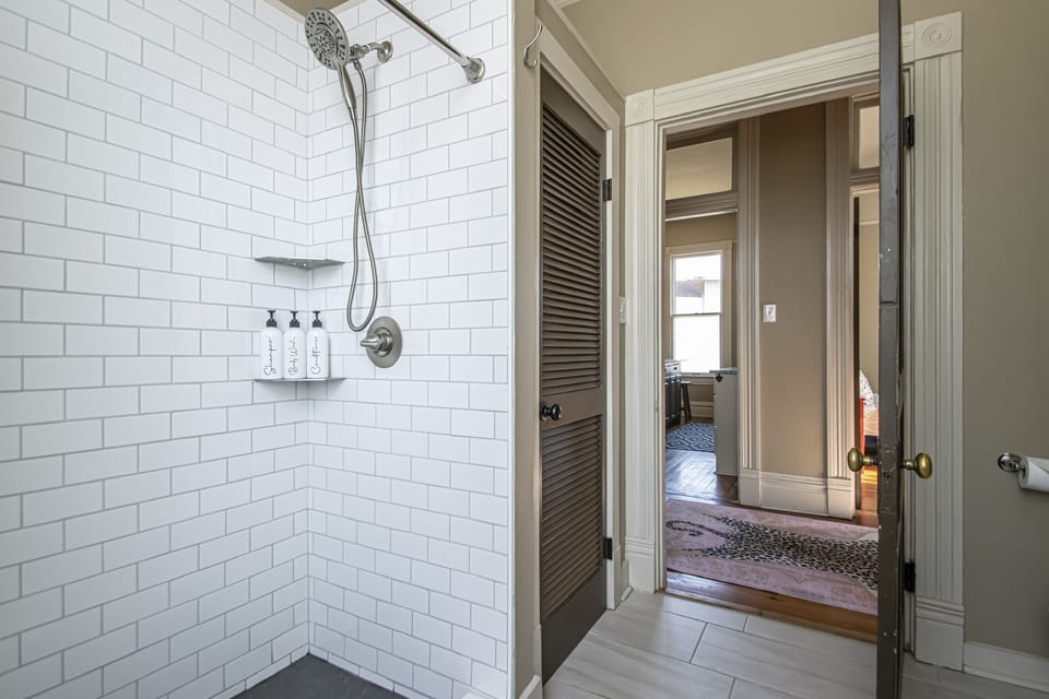 Tiled walk in shower with shampoo, conditioner and body wash.