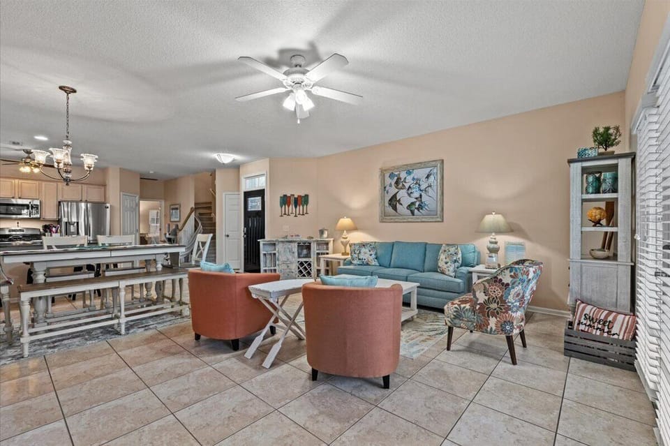Relax in your spacious open-concept living area where coastal hues and comfortable seating create the perfect atmosphere for unwinding together after beach adventures.