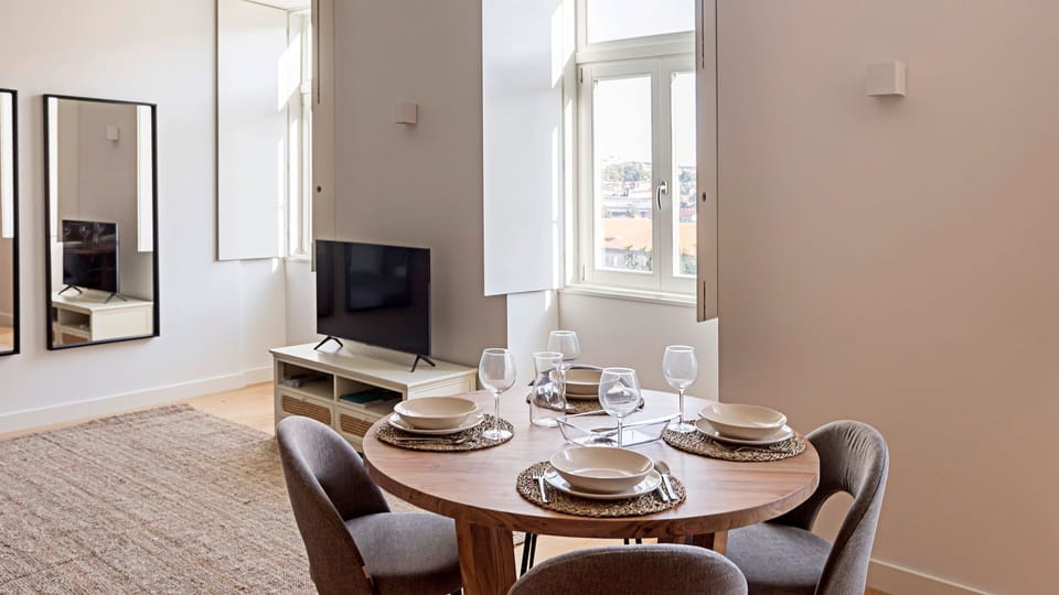 Gather for memorable meals at the beautifully set dining table, offering a perfect spot to enjoy local cuisine while admiring glimpses of the city through the windows. This inviting space fosters connection and creates lasting vacation memories.