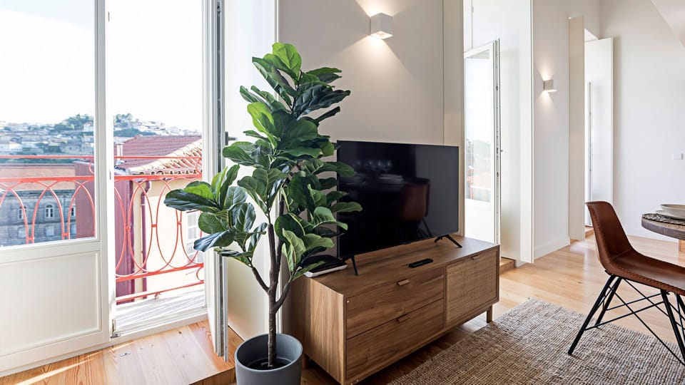 Relax and unwind in the inviting living area, where natural light pours in, and a modern flat-screen TV awaits for your entertainment after a day of exploring. Step onto the balcony for a breath of fresh air and charming city views. #LivingRoomGoals #Ente