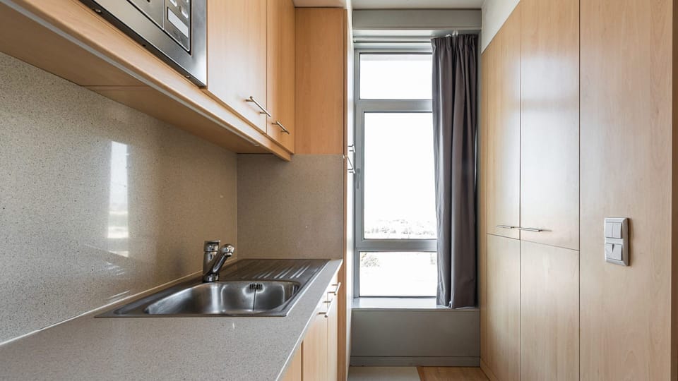 Compact kitchenette with lots of storage cabinets #spacious #organization #lovelystay #airbnbporto