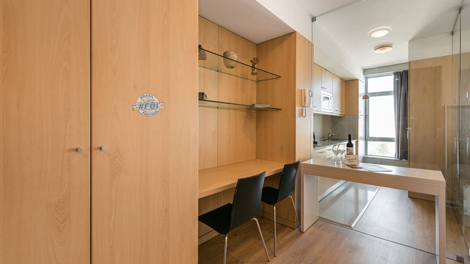 Dining + working area, with a spacious desk to use your computer and a little table to enjoy your meals #practical #simple #airbnbporto #lovelystay
