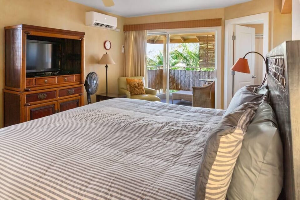 King bed with en suite bathroom and lanai off bedroom