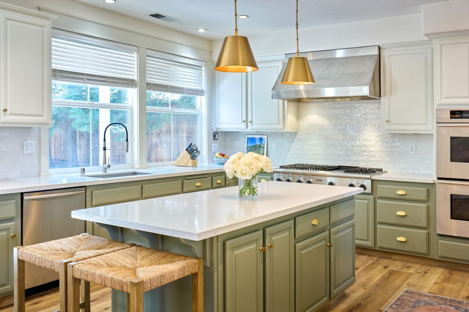 Kitchen with pool view, BBQ island, and 85" smart TV viewable while cooking.