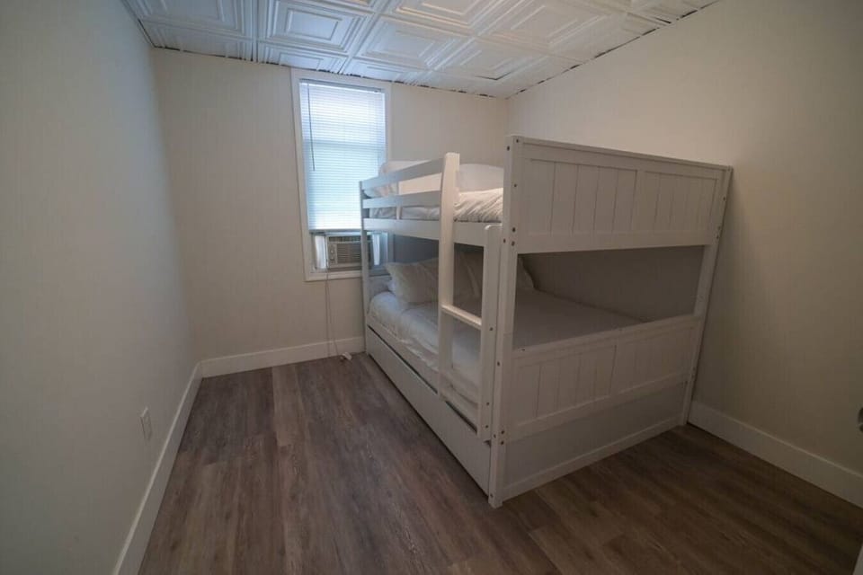 A cozy bedroom for two with a window that lets in plenty of natural light