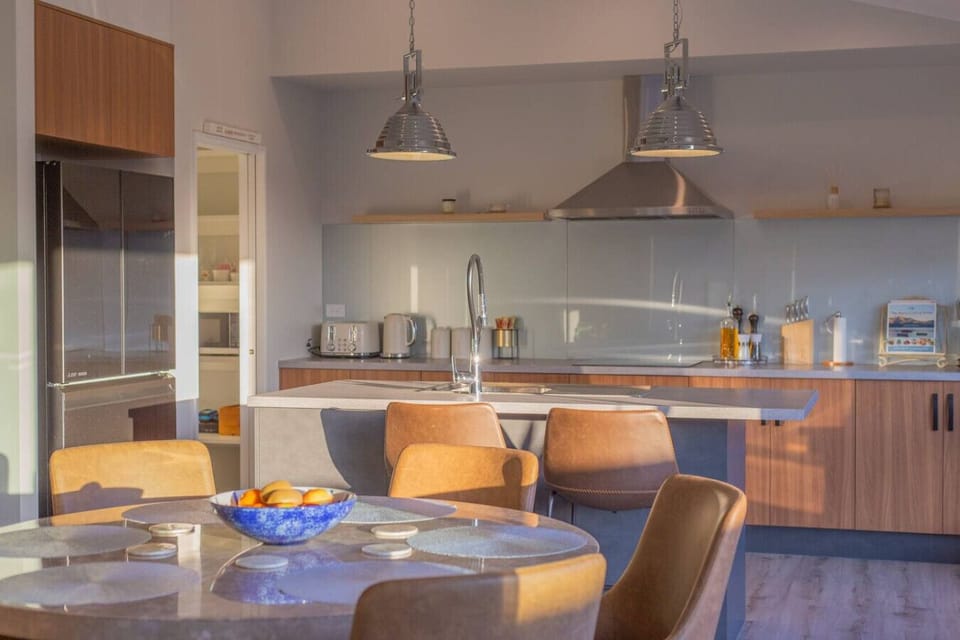 Gather your family around the marble island while sunlight streams through those industrial pendants—this is where your mornings (and memories) happen.