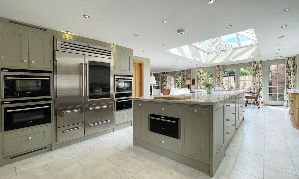 3 electric ovens & a plate warmer, either side of Wolf Sub-Zero American fridge 