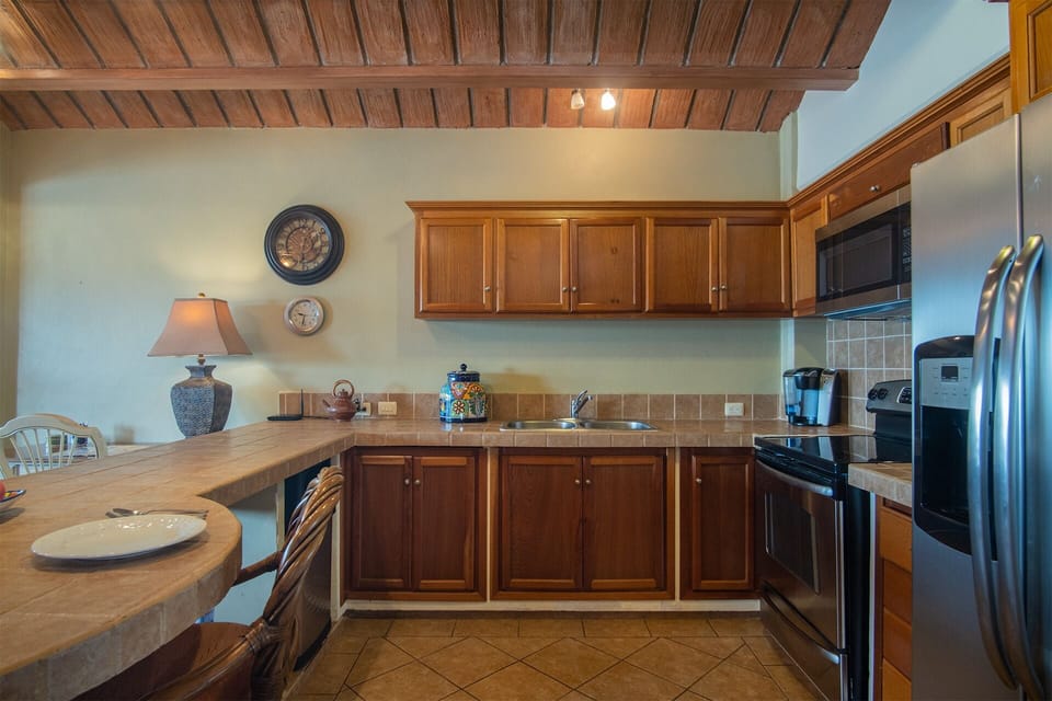 the kitchen with its cabinetry, appliances, and spacious countertop