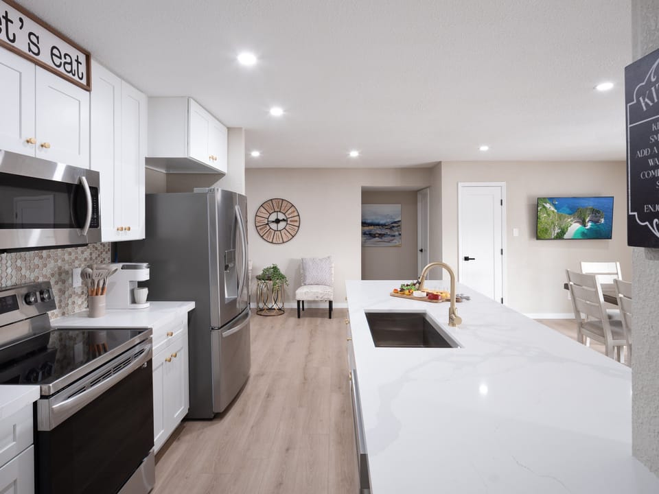 Open concept kitchen with dining room, large island, designated workspace, and fully stocked with all basic cooking essentials