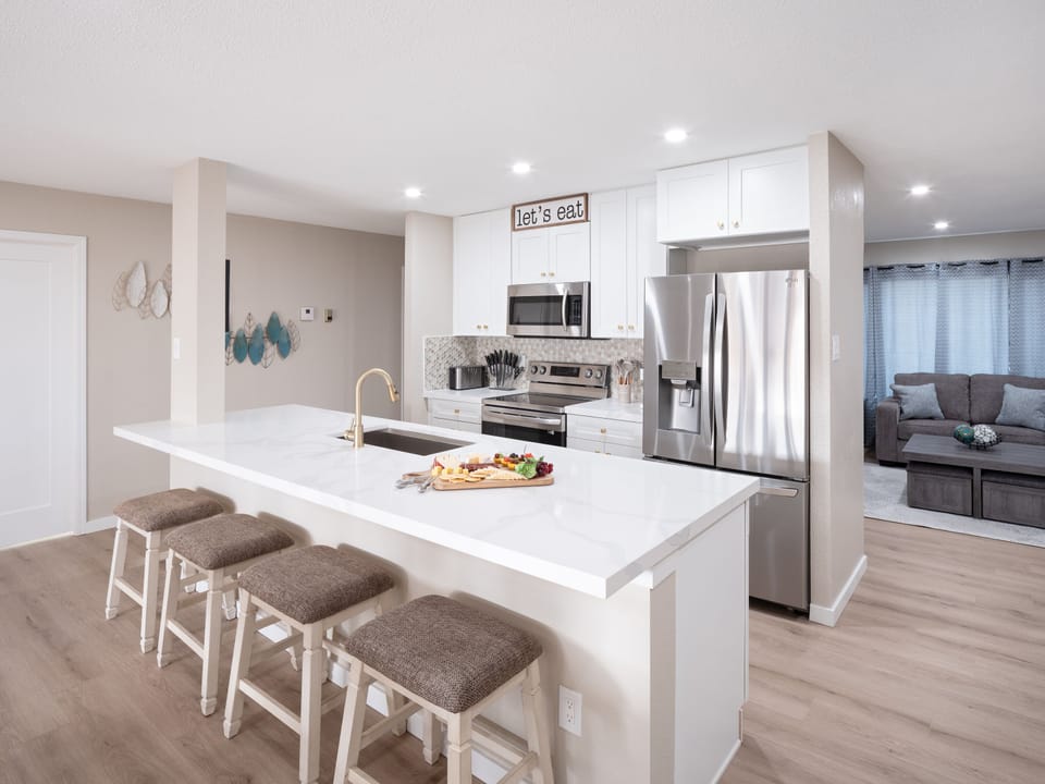 Open concept kitchen with dining room, large island, designated workspace, and fully stocked with all basic cooking essentials