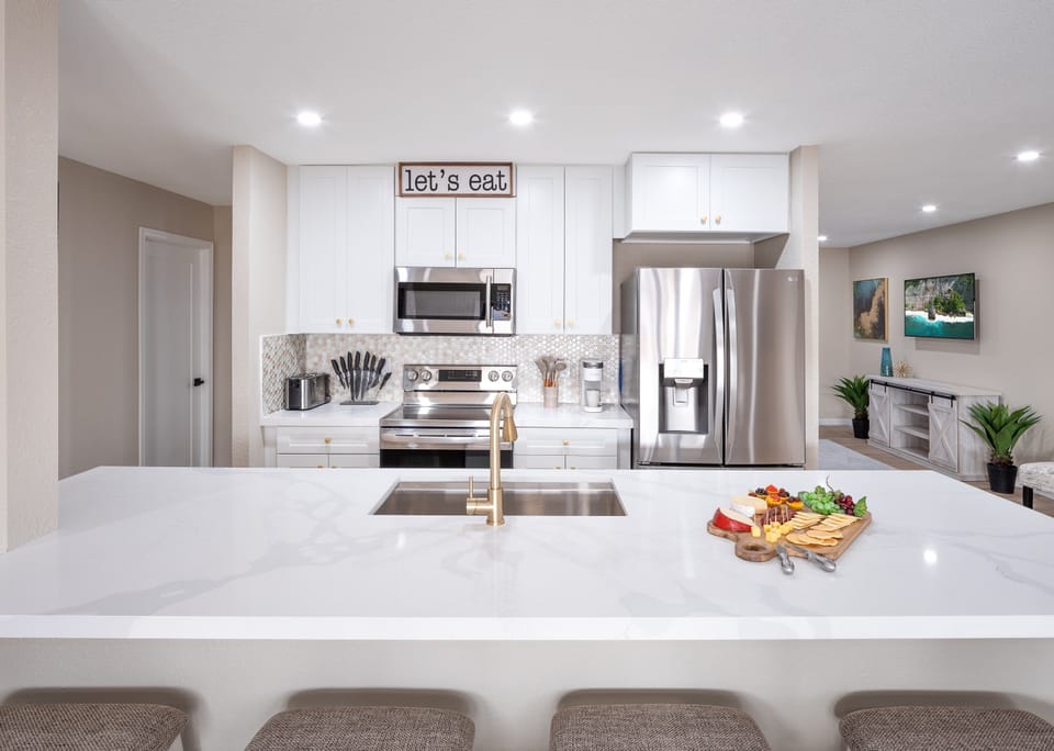 Open concept kitchen with dining room, large island, designated workspace, and fully stocked with all basic cooking essentials
