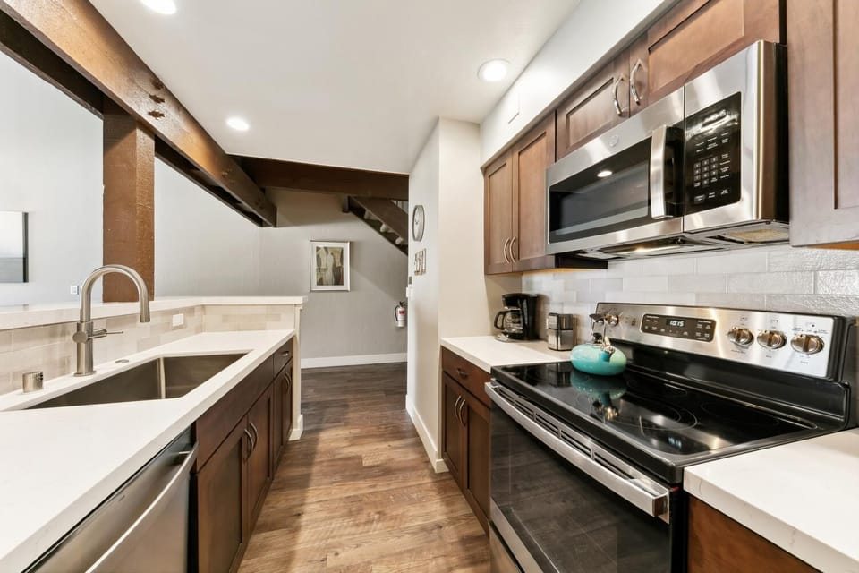 Your modern kitchen features sleek appliances, rich wood cabinetry, and spacious countertops perfect for preparing meals during your stay.