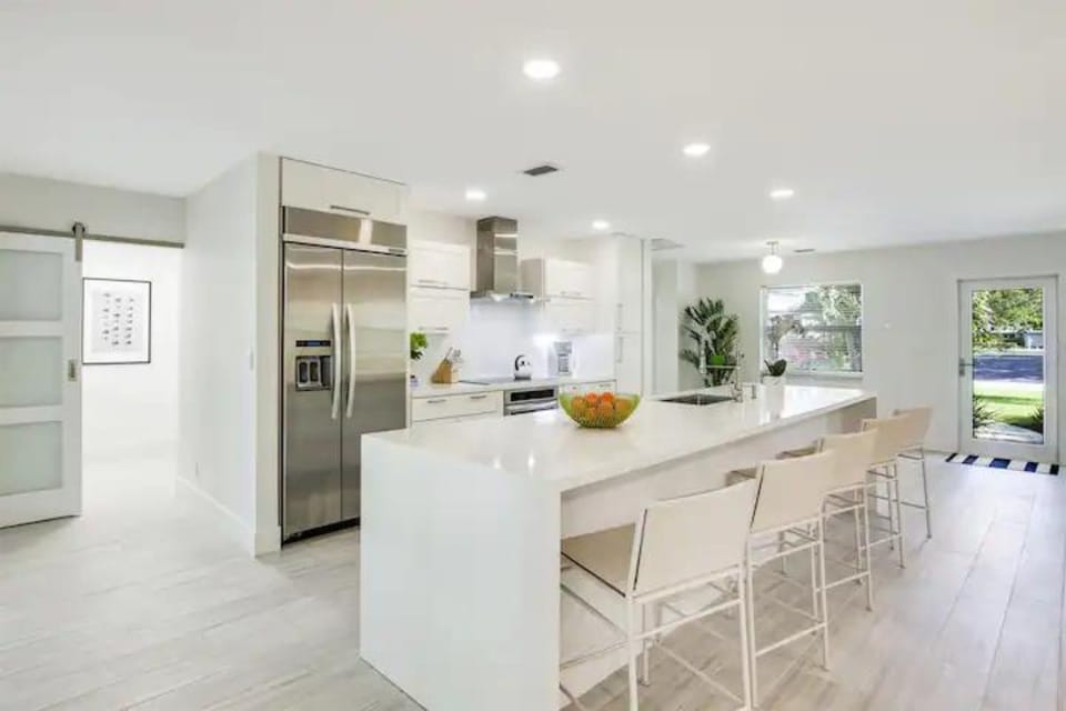 Indulge in our modern chef's kitchen, complete with a spacious island seating 5. Stainless steel appliances, including a double-door fridge and ice maker, set the stage for culinary excellence.