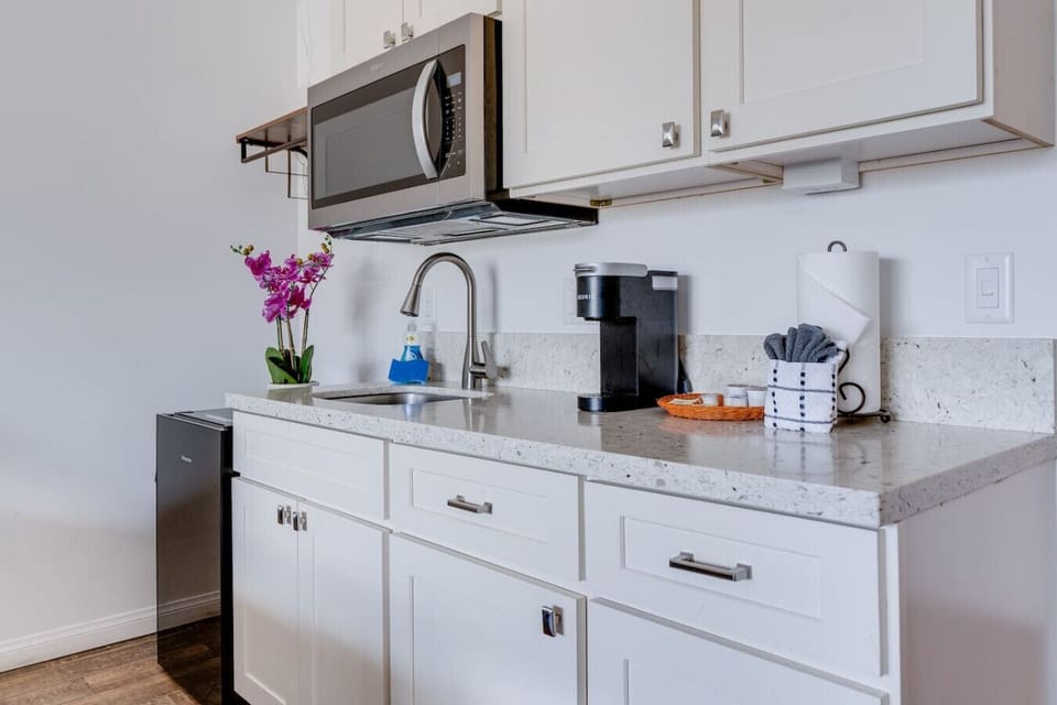 Kitchenette equipped with essential tools for preparing small meals. There is no stove or oven, but it includes a portable hot plate, skillet, and other basic cookware