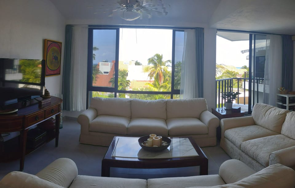 Sitting room with picture windows, balcony, and ocean views