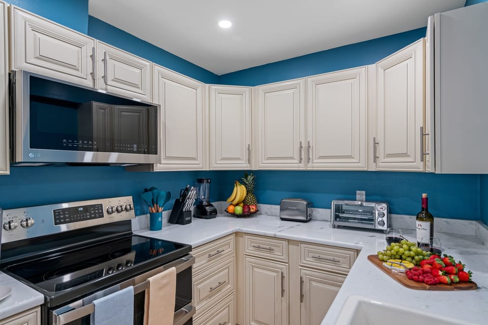 Surrounding the kitchen are pristine white cupboards, providing ample storage for your cookware, utensils, and pantry essentials.