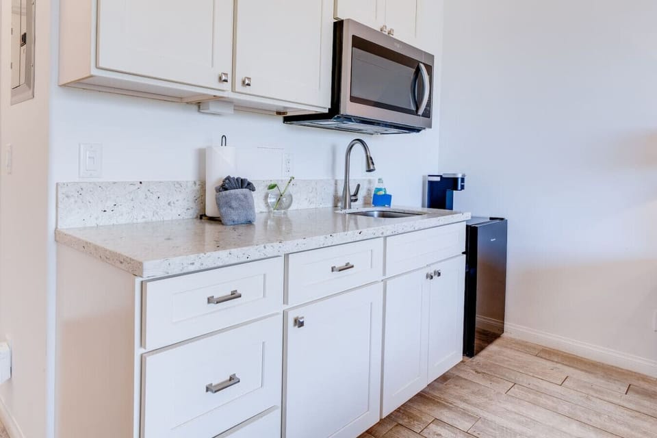 Kitchenette equipped with essential tools for preparing small meals. There is no stove or oven, but it includes a portable hot plate, skillet, and other basic cookware