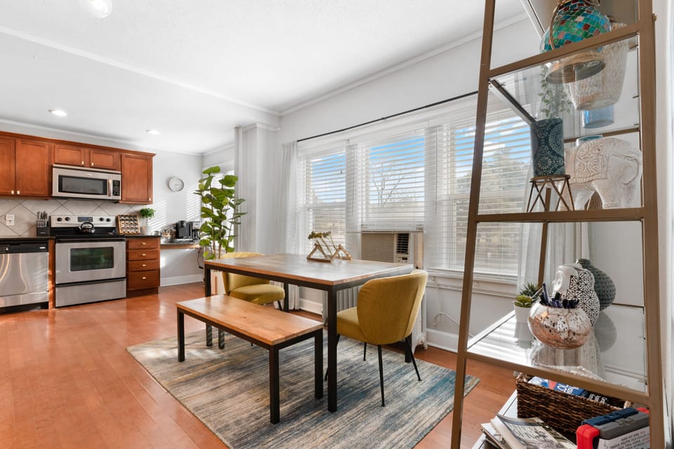 Sun-filled dining space with modern seating and large windows, perfectly positioned between the kitchen and living area—ideal for meals at home before walking across the street to the Nelson-Atkins Museum of Art or heading to the nearby Plaza.
