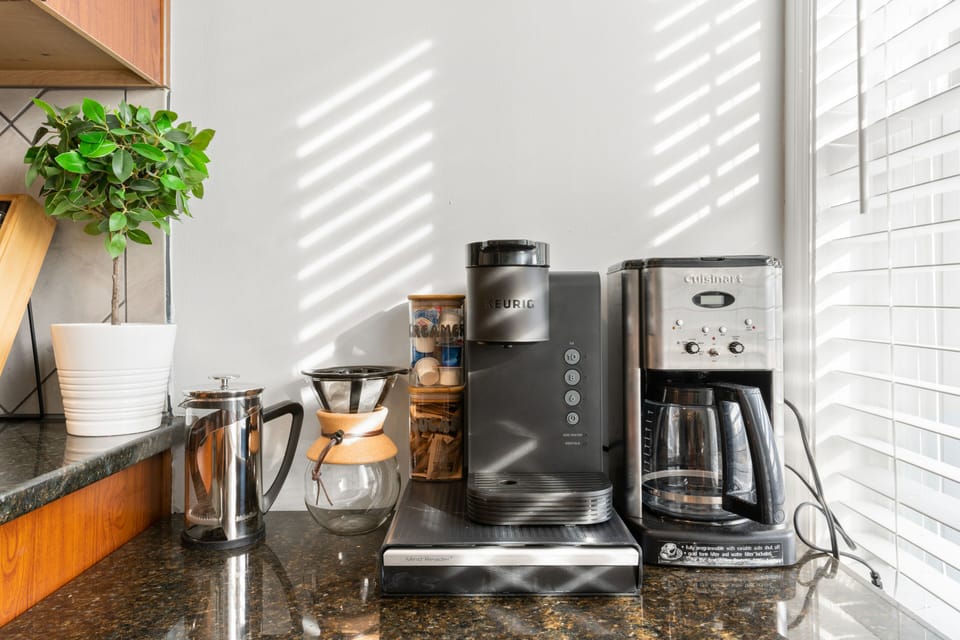Thoughtfully stocked coffee bar with multiple brew options and natural light—start your mornings slow before walking across the street to the Nelson-Atkins Museum of Art.