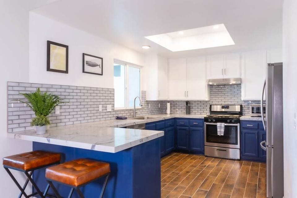 Open-plan kitchen with brand new appliances, granite countertops and breakfast bar.