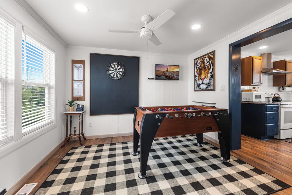 Game Room with full-sized foosball table, regulation dart board, and smart TV.