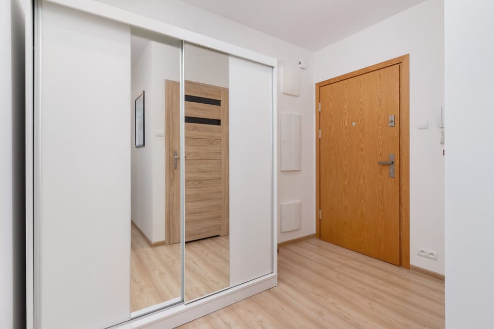 A hallway with built-in mirrored wardrobes, offering plenty of storage space.
